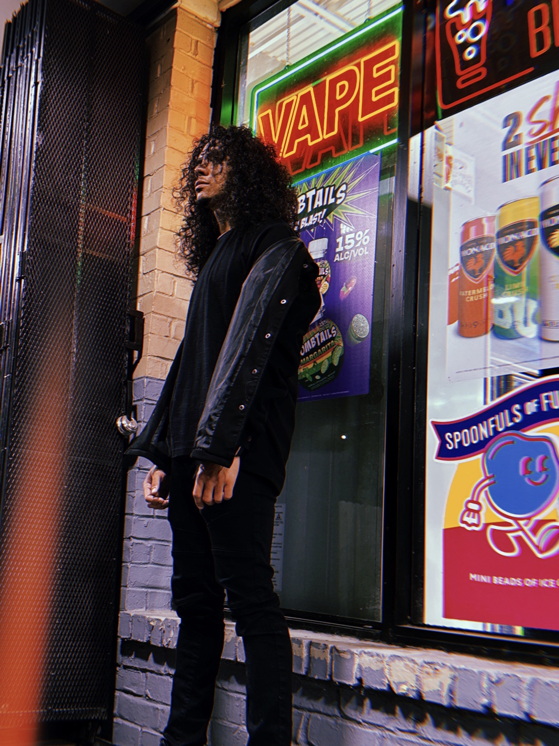 THEOFFICIALRAM standing outside a neon-lit storefront